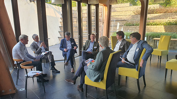 JBR Table ronde des cadres intérimaires WHOA sept hommes en costume qui se parlent